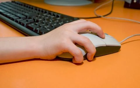 Baby hand on computer mouse Stock Photos
