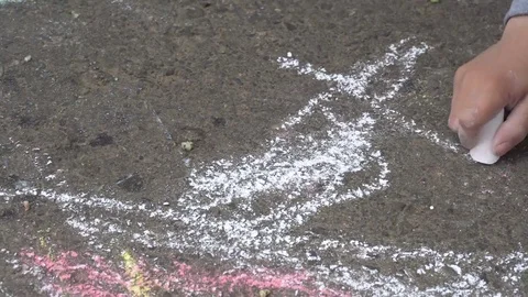 Baby hand drawing with colored chalks on the pavement Stock-Footage 76215620