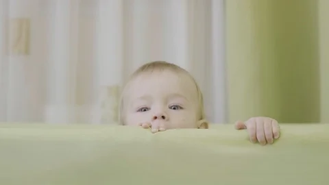 Baby hands holding cot margin, smiling child face rising up  Stock Footage 93266233