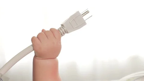 Baby hands play with electrical cable Stockbeeldmateriaal 121941926