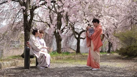 Baby Held in Kimono Group Under Flowering Trees Stockbeeldmateriaal 344861671