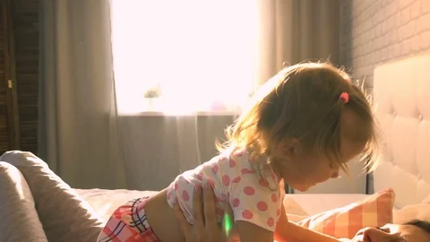 Baby hugging with mom in bed Stock Footage
