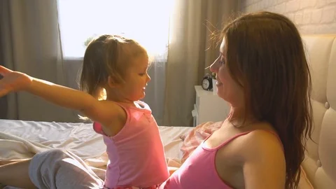 Baby hugging with mom in bed Stock Footage 74002563