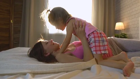 Baby hugging with mom in bed Stock Footage 77876846