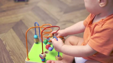 Baby infant developing fine motor skills playing bead maze roller coaster toy Stock Footage 165464777