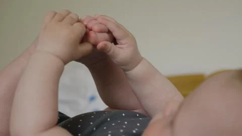 Baby Joyfully Exploring Their Tiny Feet with Curiosity Stock Footage 317518828