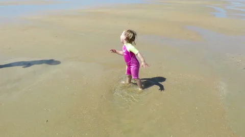 Baby jumping puddle at beach Stock Footage 58250131