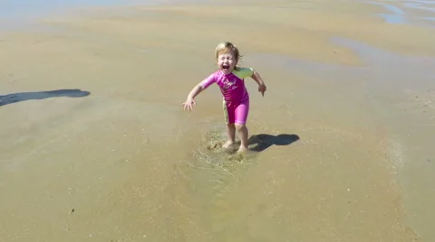 Baby jumping puddle at beach slowmotion Stock Footage 58274553