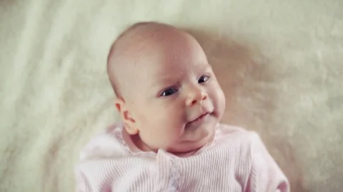 Baby laughing while lying on her back in bed Stock-Footage 80081335