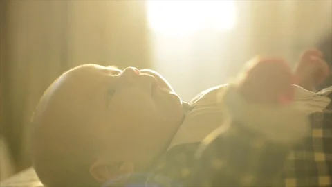 A baby laying on a sofa in sunset 動画素材 88469308