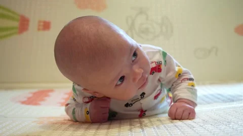 Baby learn head control, 2 month old baby boy lifting head lying on tummy on Stock Footage 160570623