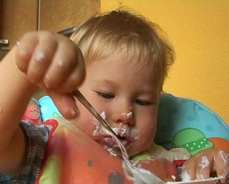 Baby learning to feed himself Stockbeeldmateriaal 513920