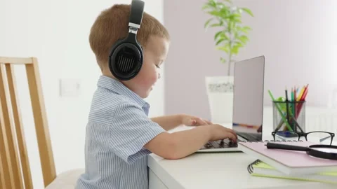 Baby learning online using laptop headphones, child typing computer, home study Stock Footage 205097011