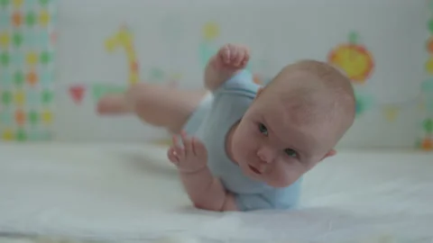 Baby learning to roll over by herself. Stock Footage 168628580