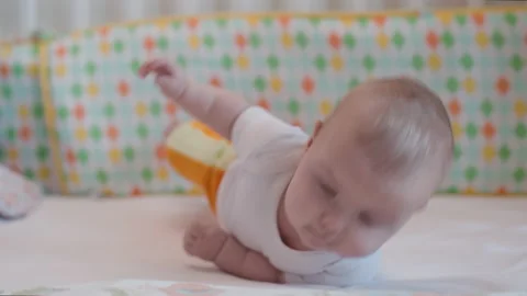 Baby learning to roll over by herself. Stock Footage 220081990