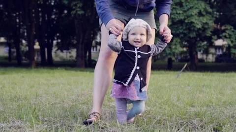A baby learning to walk Stock Footage 77634943
