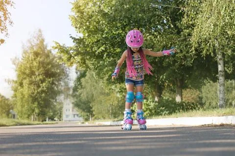 Baby learns to rollerblade, trying to keep his balance. Stock Photos