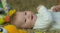 The baby lies on the bed look and smile . Close-up portrait view 4k or 4k+ Resolution