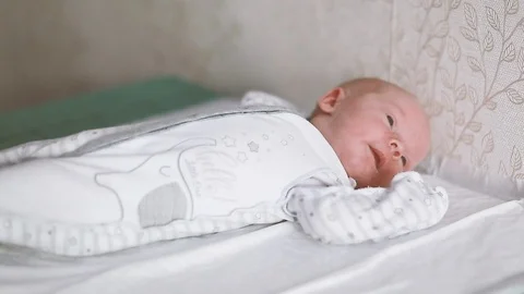 The baby lies on the changing table and tosses Stock Footage 112656053