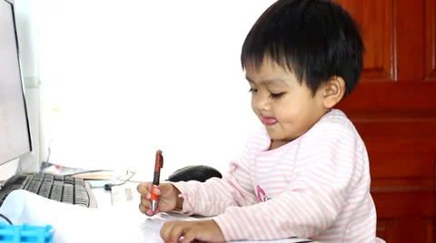 Baby looking at computer and writing 動画素材 37873258