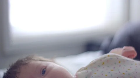 Baby lying in bed and looking towards camera Stock Footage 107615820