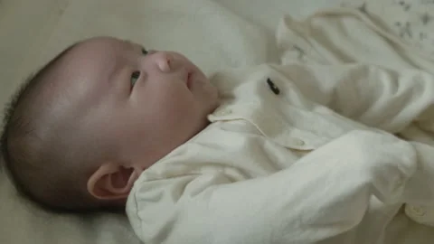 A baby lying on the bed and looking at the mobile. Stock Footage 194708095