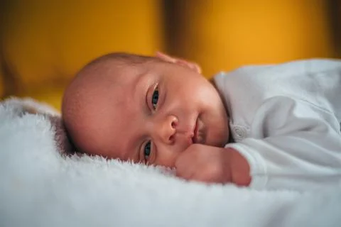 Baby lying on the bed at home Stock Photos