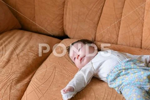 Baby lying on the couch. family, parenthood and motherhood concept - close up Stock Photos