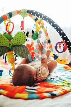 Baby lying on Developing rug. playing in Mobile. Stock Photos
