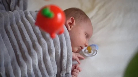 Baby lying in his bed, looking at toys Stock Footage 100198909