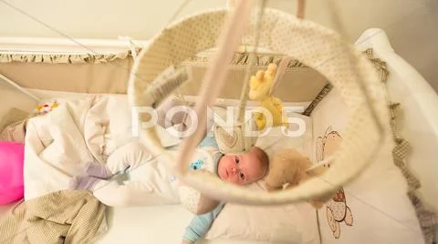 Baby lying in his cot Stock Photos