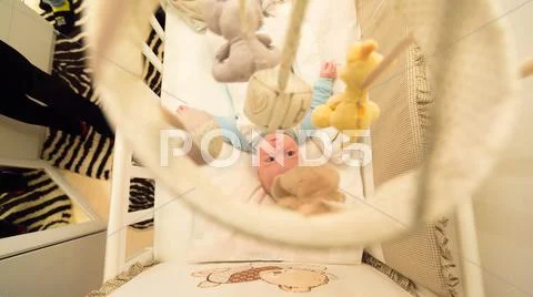 Baby lying in his cot Stock Photos