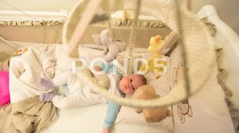 Baby lying in his cot Stock Photos