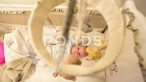 Baby lying in his cot Stock Photos