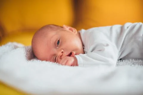 Baby lying on a while blanket Stock Photos