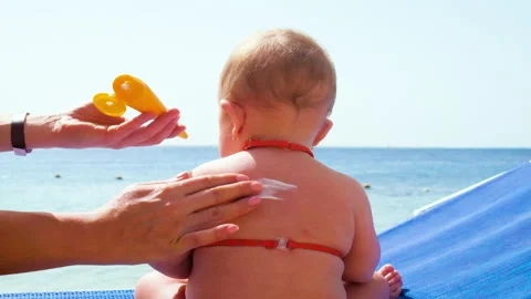 Baby maje sunscreen on the beach. selective focus. Stock Footage 154273601