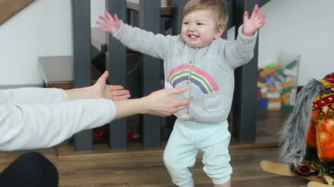 Baby making first steps. Kid learning how to walk Stock Footage 147660542
