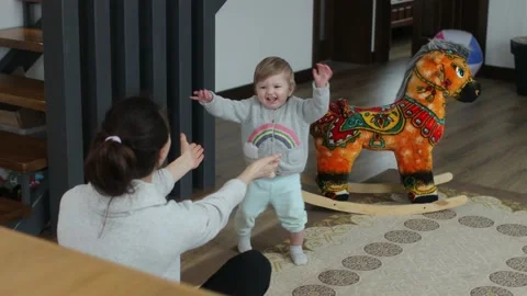 Baby making first steps. Kid learning how to walk Stock Footage 147660595
