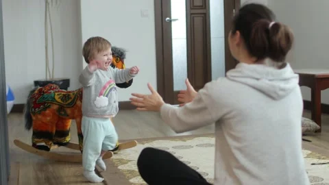 Baby making first steps. Kid learning how to walk Stock Footage 147660636