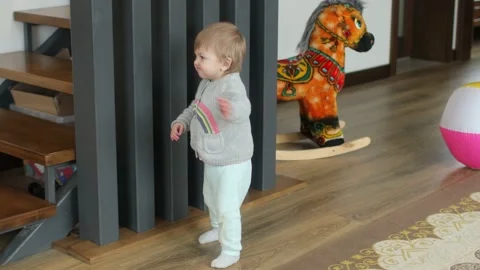 Baby making first steps. Kid learning how to walk Stock Footage 147660799