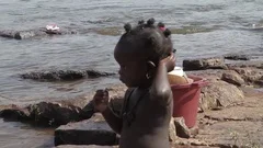 woman and baby taking bath in river - Gu, Stock Video