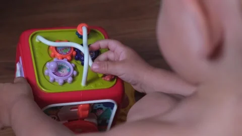 A baby or the hands of a small 1-2 year old child play with toy watch insoles Stock Footage 275246600