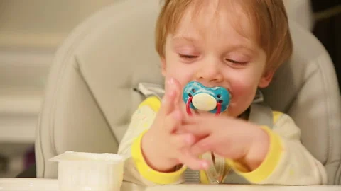 Baby with a pacifier sitting at the table Stock Footage 147191025