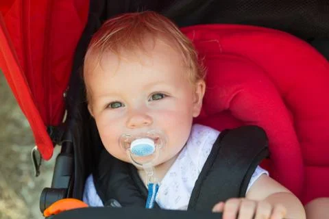 Baby with a pacifier in a stroller Stock Photos