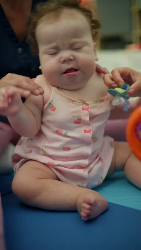 Baby peacefully sleeping while sucking a pacifier, a toy nearby and a parent's Video stock 343140158