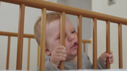 Baby Peering Through The Crib Bars With Interest Stock Footage 292260732