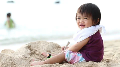 Baby play sand on the beach Stock Footage