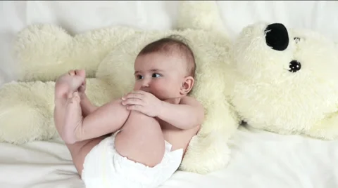 The baby is playing with bear in yellow Stockbeeldmateriaal 63764871