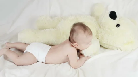 The baby is playing with bear in yellow Stockbeeldmateriaal 64583431