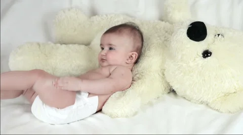 The baby is playing with bear in yellow Stockbeeldmateriaal 64583489